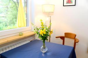 a vase of flowers on a table with a window at Ferienwohnung Jachmann, 80qm in Schönwald +10 photos