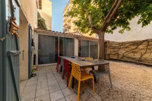 a table and chairs on a patio with a tree at Maison type Canetoise prox plage in Canet-en-Roussillon