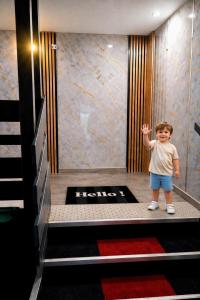 a young boy standing in a hotel lobby at The Originals City, Hôtel Mâcon Sud in Chaintré