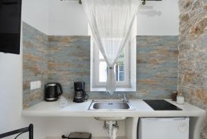 a kitchen with a sink and a window at Politimis Studio N6 in Amorgos