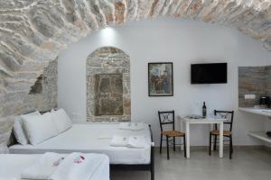 a bedroom with a bed and a table and a tv at Politimis Studio N6 in Amorgos