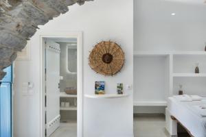 a room with white walls and a hallway with a mirror at Politimis Studio N6 in Amorgos +19 photos