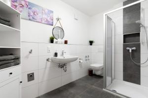 a white bathroom with a sink and a shower at White House Apartments in Kappel-Grafenhausen +141 photos