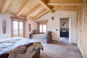 a bedroom with a bed and a couch in a room at Bellagio - Baita treeb Tramontana in Bellagio