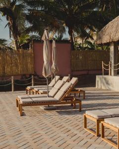 a group of lounge chairs and umbrellas on a patio at Hotel Calma Celesti in Perihuete