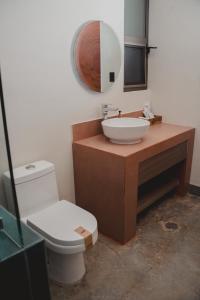 a bathroom with a sink and a toilet and a mirror at Hotel Calma Celesti in Perihuete