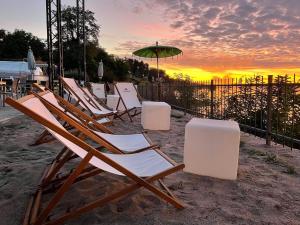 a group of lawn chairs and an umbrella on the beach at Gemütliche Wohnung in Ortsrandlage in Rüdesheim am Rhein