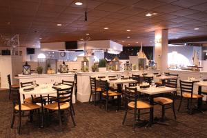a restaurant with tables and chairs and a bar at The Cove at Yarmouth in West Yarmouth