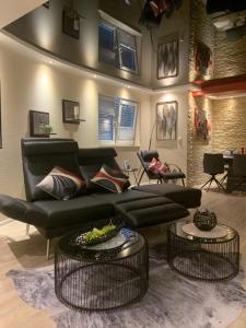 a living room with a black couch and two tables at Gemütliche Wohnung in Ortsrandlage in Rüdesheim am Rhein