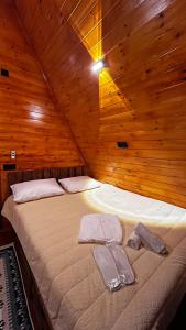 a bed in a wooden room with a wooden ceiling at Nakas cottage in Tbilisi City +104 photos