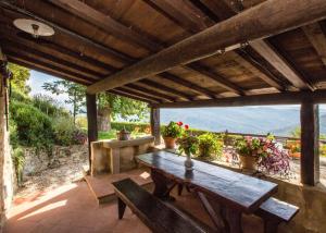 a wooden table and benches on a patio with flowers at Universal Harmony - Usignolo in Dicomano