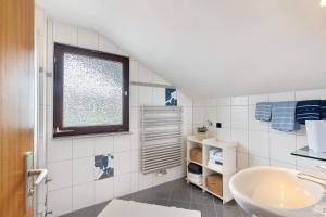 a bathroom with a sink and a tub and a window at Haus Seiler in Freudenstadt +58 photos
