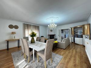 a dining room and living room with a table and chairs at Refugio Senhora Paz in Marinhas