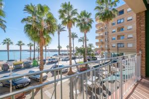 a balcony view of the beach and palm trees at Apartamento las Palmeras 1 in Benicarló