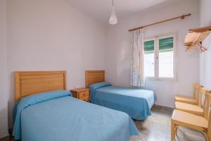a bedroom with two beds and a window at Apartamento las Palmeras 1 in Benicarló