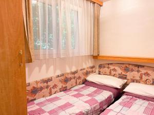 two beds sitting in a room with a window at Le sorgenti - Mobile Home 46 in Palazzuolo sul Senio
