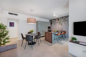 a kitchen and living room with a table and chairs at Residence Eleonora in Garda