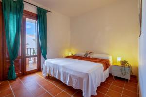a bedroom with a bed and a large window at Pentavano White House in Isola Rossa
