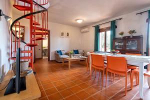 a living room with a staircase and a table and chairs at Pentavano White House in Isola Rossa