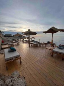 a beach with lounge chairs and umbrellas and the ocean at La Cantina in Giovinazzo