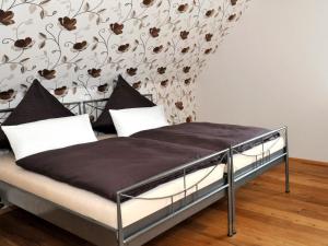 a bed in a bedroom with a floral wallpaper at Ferienwohnung Bock Feldmannshof in Drolshagen
