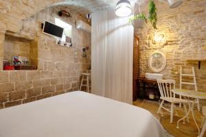 a bedroom with a bed and a stone wall at La Cantina in Giovinazzo