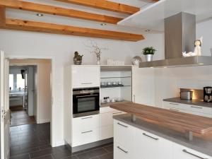 a kitchen with white cabinets and a wooden counter top at Ferienwohnung Bock Feldmannshof in Drolshagen