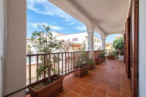 an outdoor balcony with potted plants on it at Pentavano White House in Isola Rossa