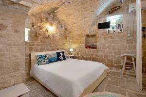 a bedroom with a bed in a stone wall at La Cantina in Giovinazzo