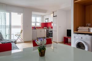 a kitchen with a white table and red cabinets at S23 Sa Caleta in Lloret de Mar