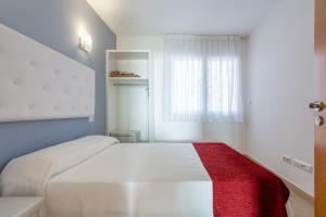a bedroom with a white bed with a red blanket at S23 Sa Caleta in Lloret de Mar +12 photos