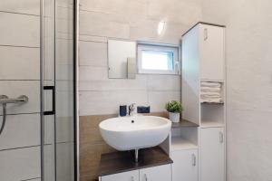 a bathroom with a white sink and a shower at Haus Zum Stumpfen Turm mit Sauna in Morbach