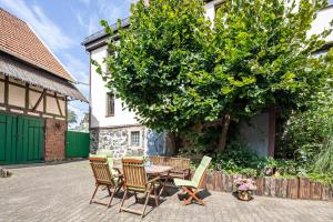 a patio with a table and chairs under a tree at Bachmanns Ferienwohnung 2 in Schotten