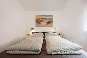 a bedroom with two beds and a painting on the wall at Haus Zum Stumpfen Turm mit Sauna in Morbach