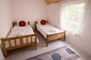 two beds in a small room with a window at Ardi Selimaj in Valbonë