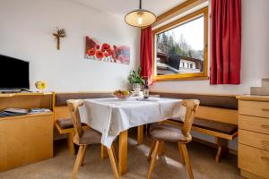 a dining room with a table and chairs and a window at Manuel's App Watschinger - Enzian in Sesto