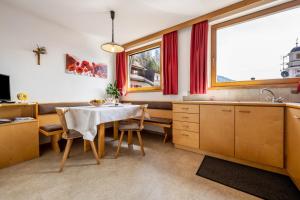 a kitchen with a table and chairs and a window at Manuel's App Watschinger - Enzian in Sesto