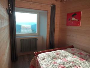 a bedroom with a bed and a window at Gîte du Bachat in Vorey