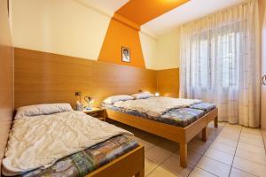a bedroom with two beds and a window at Appartamento Alexander in Tignale +18 photos