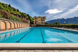 a swimming pool with mountains in the background at Appartamento Alexander in Tignale