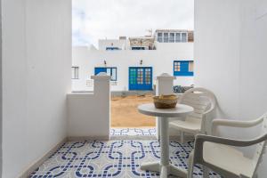 a table and chairs in a room with a view of a building at El Sombrerito 4 in Caleta de Sebo +14 photos