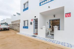 a white house with a truck parked in front of it at El Sombrerito 4 in Caleta de Sebo