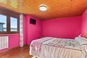 a pink bedroom with a bed and a window at Casa Nueva in Salas