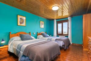 two beds in a room with blue walls at Casa Nueva in Salas
