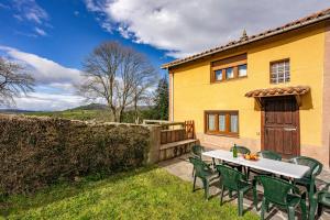 a table and chairs in front of a yellow house at Casa Nueva in Salas