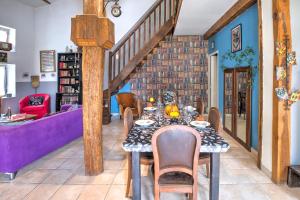 a dining room with a table and a purple couch at Le Magicogite - Harry Potter in Larocal