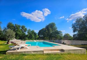 a swimming pool in a yard with a chair at Le Magicogite - Harry Potter in Larocal