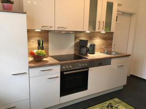 a kitchen with white cabinets and a sink at Hannes und Stefanie Fleischer in Wangen +14 photos