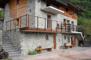 a stone building with a balcony and stairs on it at Maso Plocech App Vacanze in Pergine Valsugana