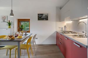 a kitchen with a dining table and yellow chairs at Maso Plocech App Vacanze in Pergine Valsugana +21 photos
